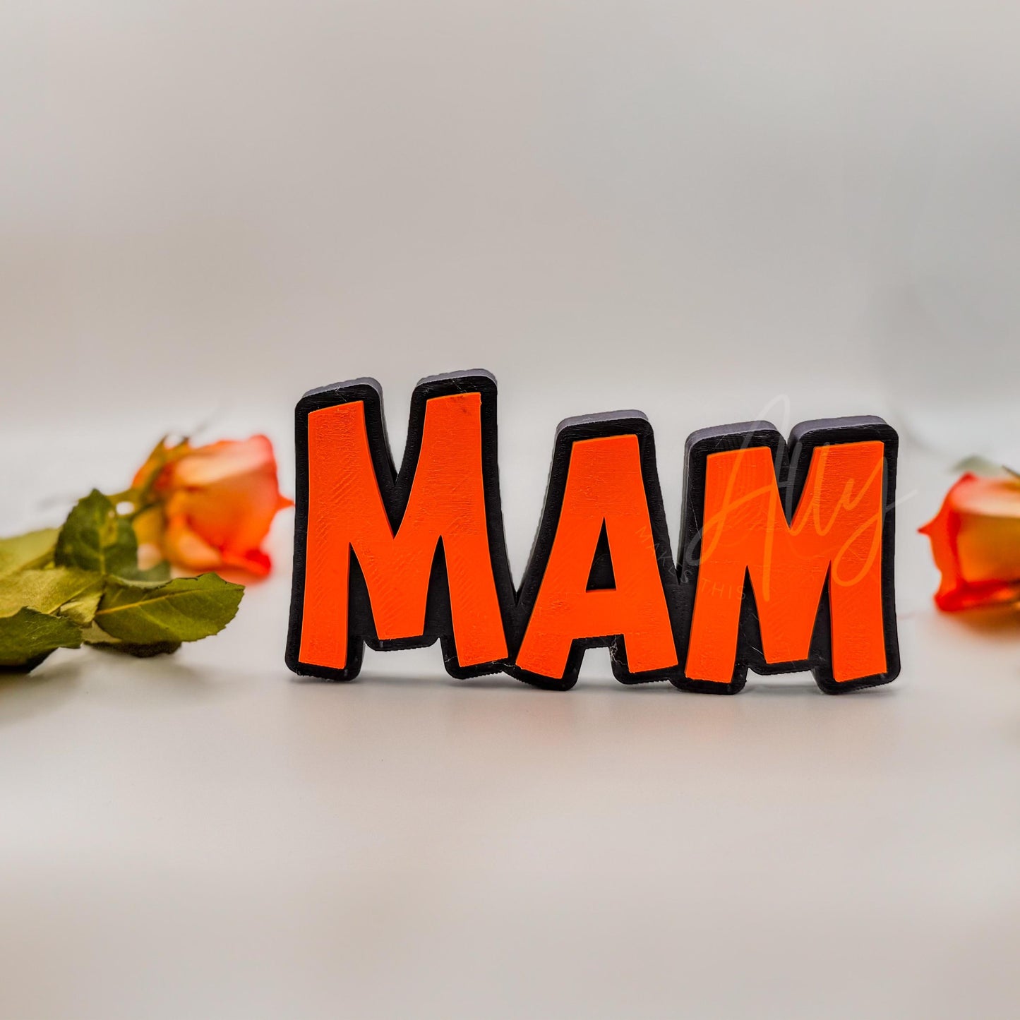 3D printed nameplate with a dark blue base and mandarin orange lettering. Freestanding and customisable, perfect for a personalised gift
