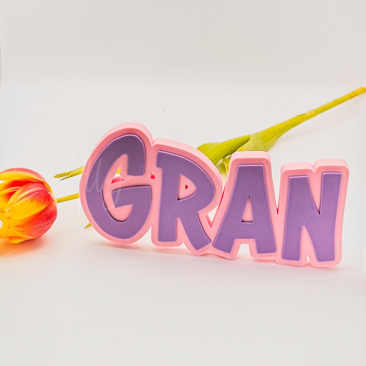 3D printed GRAN nameplate with a light pink base and purple lettering. Freestanding and customisable, perfect for a personalised Mothers Day gift, shelf decor, or a thoughtful keepsake