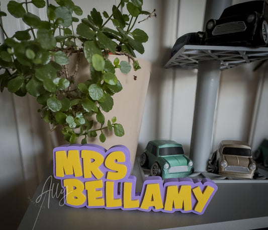 3D printed nameplate with a purple background base and yellow lettering. Freestanding and customisable, perfect for a personalised gift